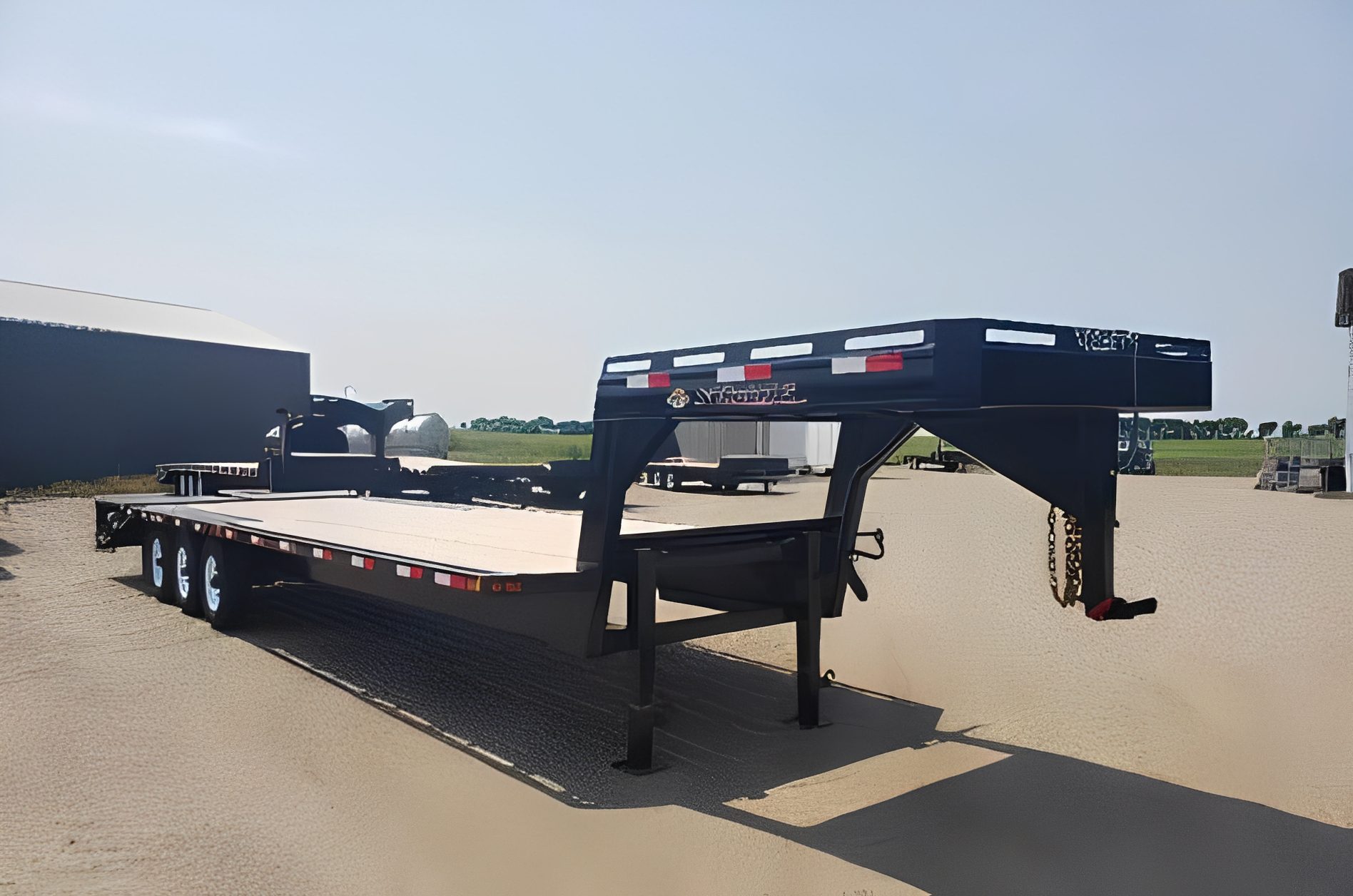 Large flatbed trailer on gravel lot
