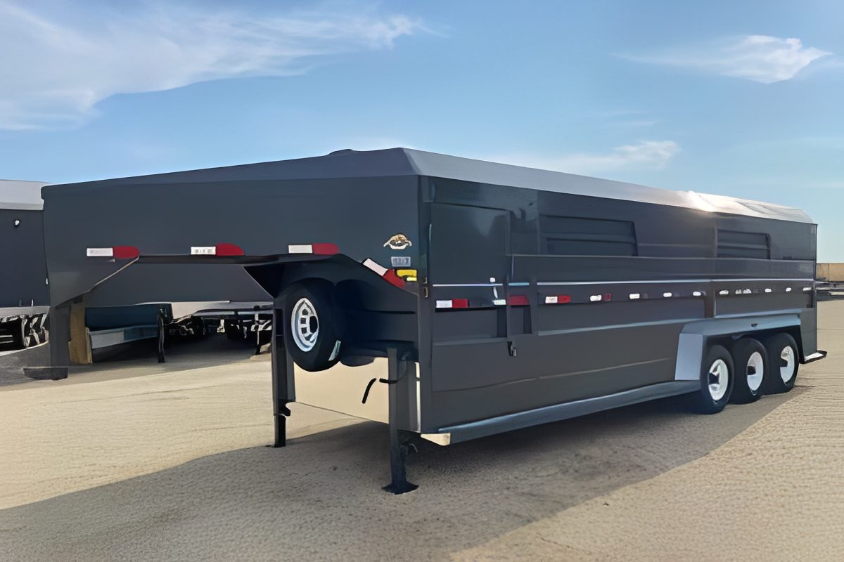 Triple-axle livestock trailer under blue sky