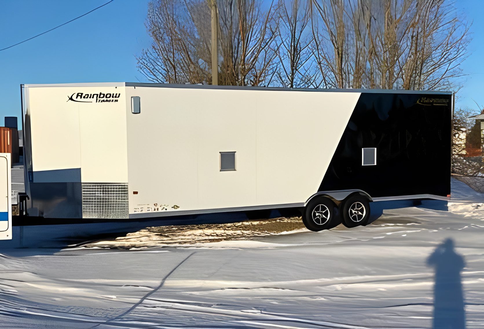 Enclosed trailer parked on snowy ground.