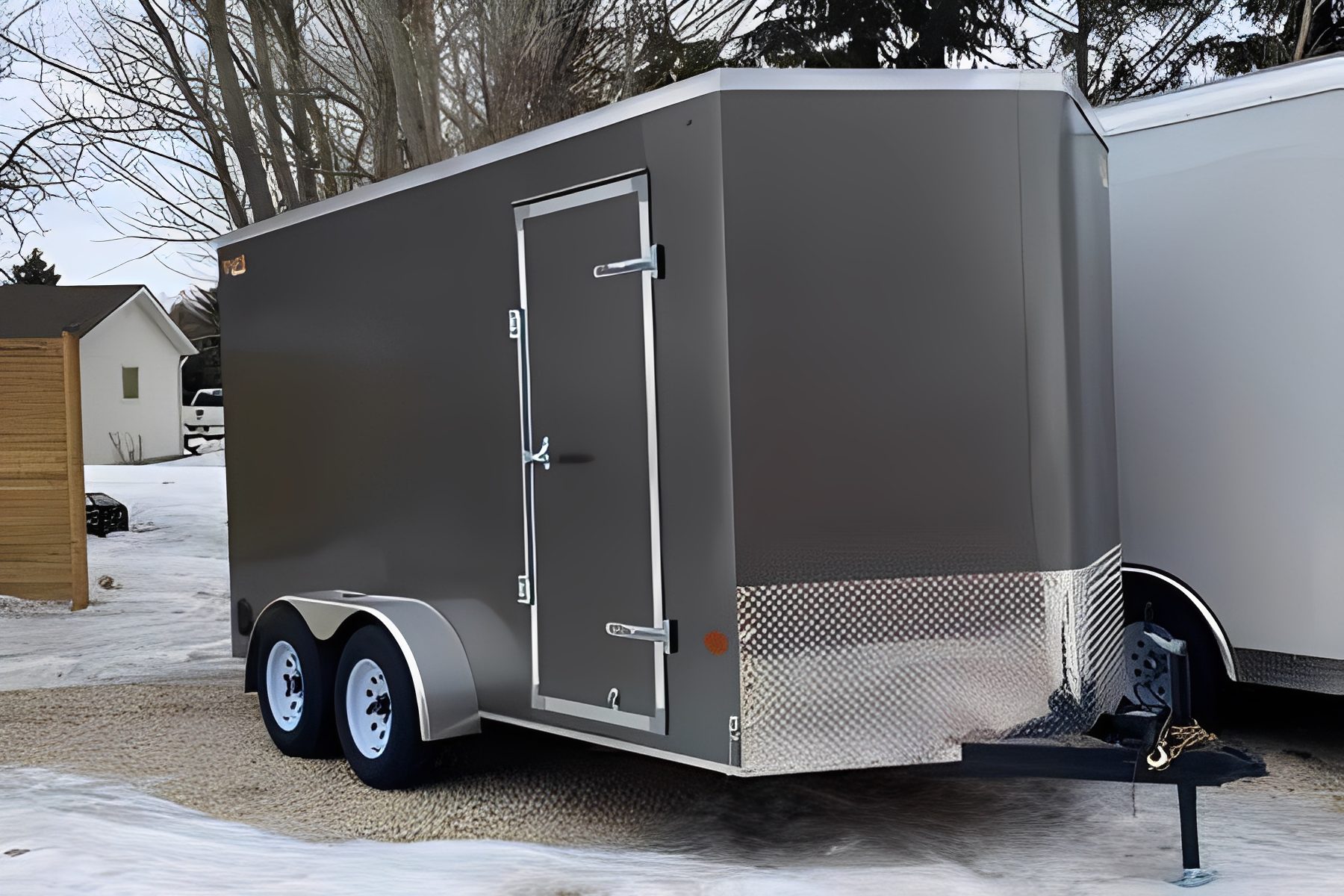 Gray enclosed trailer parked on snowy ground