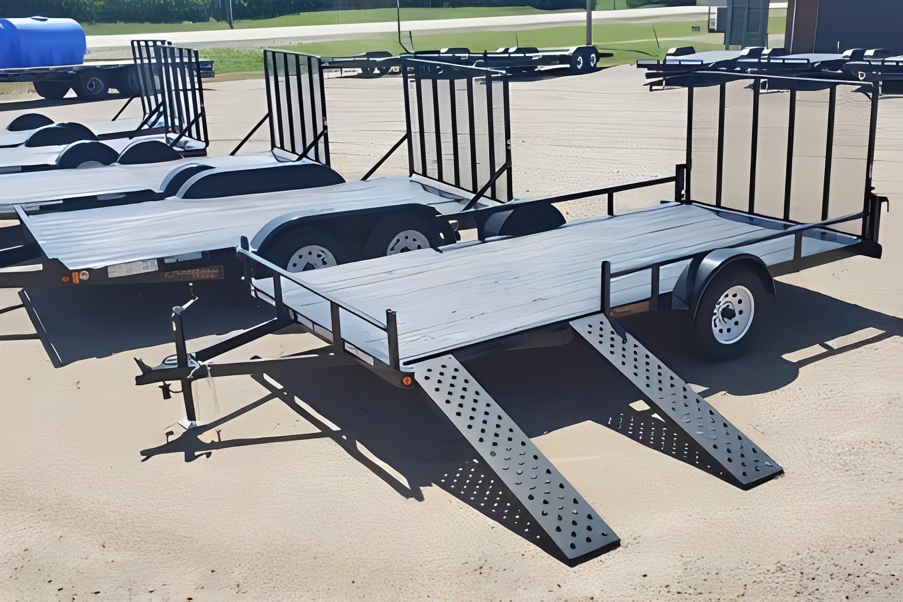 Empty flatbed trailers under bright sunlight.