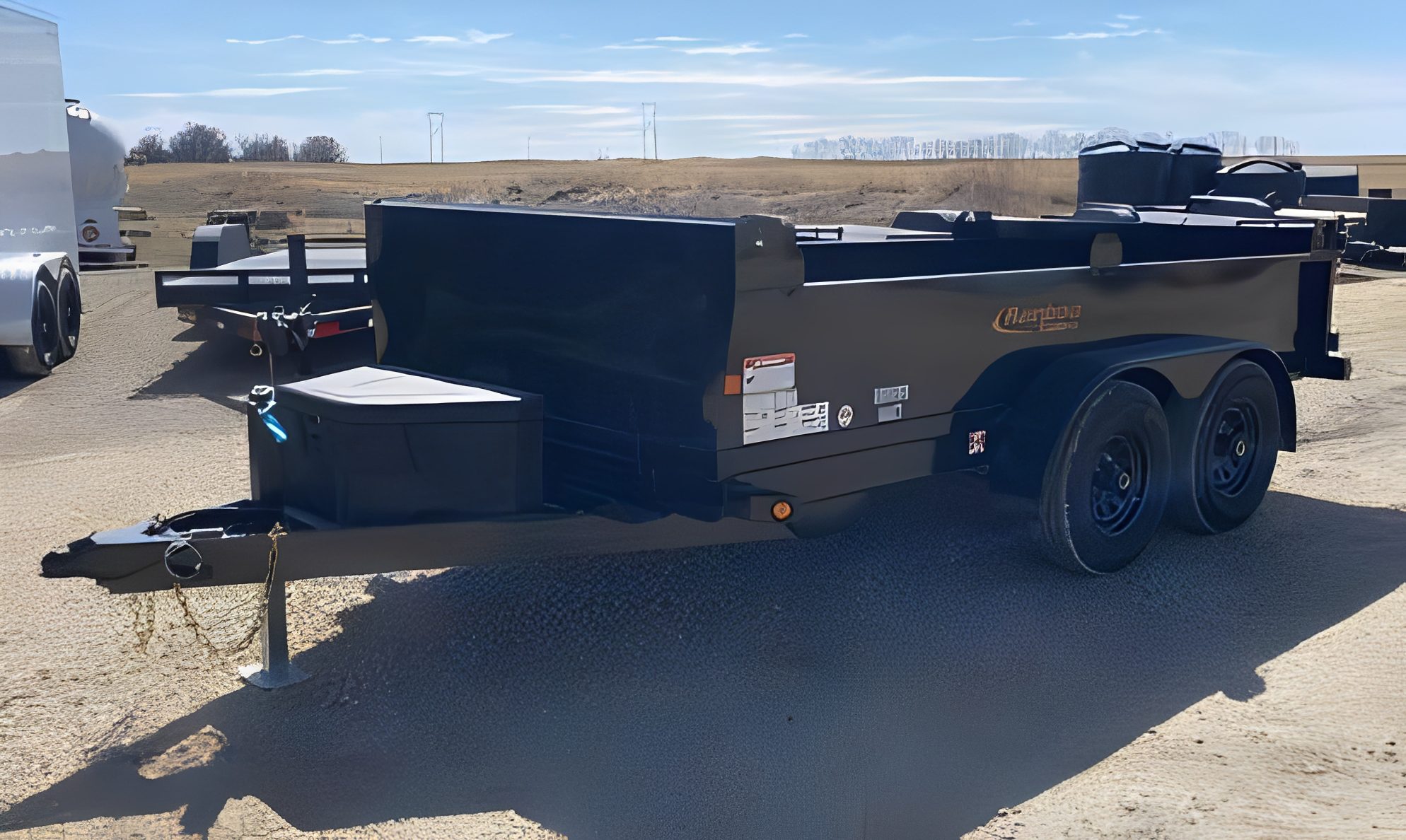 Black trailer parked outdoors under clear sky